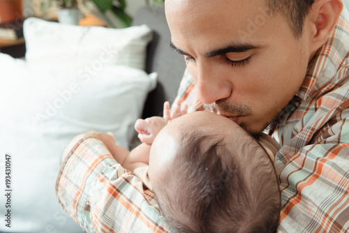 Foto Father tenderly kissing newborn baby head showing affection