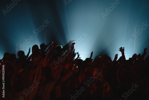 Fotografi Silhouette of crowd with hands raised at music concert or festival
