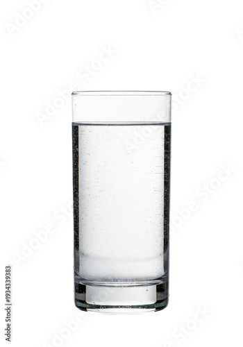 A tall crystal highball glass of pure cold water with condensation on a reflective white background. Concept of purity and liquid refreshment