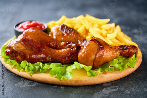 Wallpaper Mural Grilled chicken drumsticks with ketchup and french fry on a black table. Torontodigital.ca