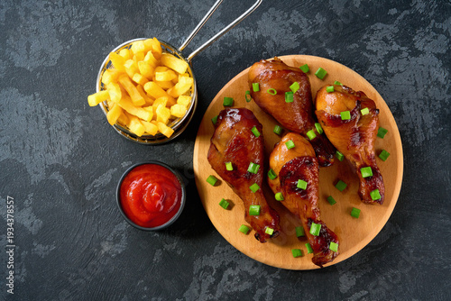 Wallpaper Mural Fried crispy chicken legs with ketchup and french fry on a black table, top view. Torontodigital.ca