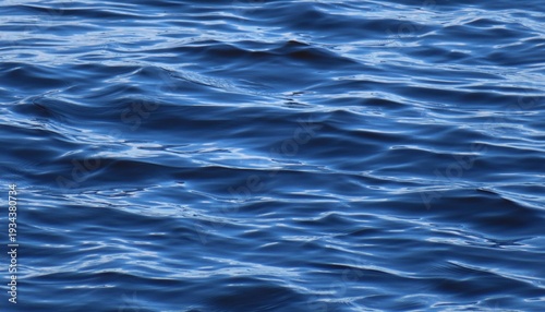 Bright blue water surface with soft waves as a background