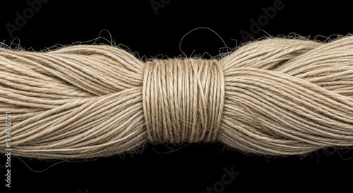 bundle of cream colored twine on black background