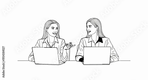 Two women in collared shirts sit at laptops, talking and gesturing