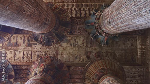 Egypt. Esna temple hypostyle hall with massive painted columns and colorful hieroglyphic reliefs on ceiling in Egypt, ancient Roman-era architecture with preserved pigments and carvings.