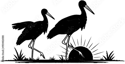 Two black silhouettes of birds, one smaller, stand in grass with a rising sun behind them