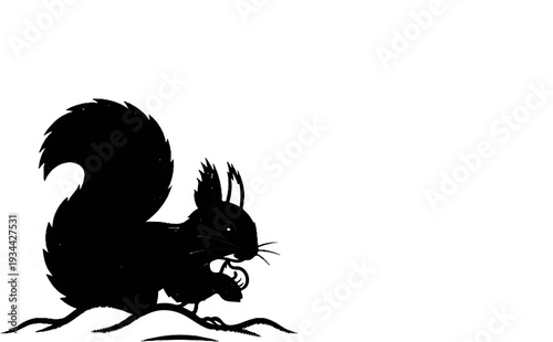Black silhouette of a squirrel holding a nut on a branch
