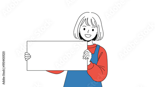 Smiling young girl in a red sweater and blue overalls holds up a large blank white board for custom text or advertising.