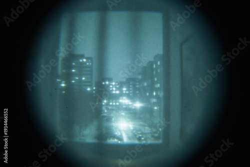 Quadro su tela Authentic point of view through a night vision device looking at a city street at night with grain and artifacts