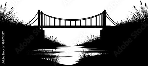 Simple suspension footbridge crossing a marshy river with tall reeds