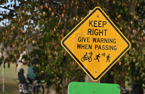 Bike trail sign that says Keep right, Give warning when passing