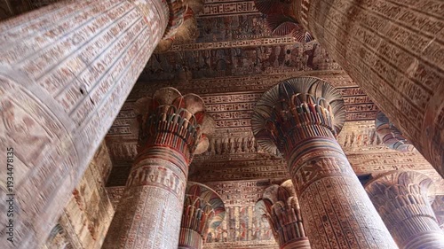 Egypt. Esna temple hypostyle hall with massive painted columns and colorful hieroglyphic reliefs on ceiling in Egypt, ancient Roman-era architecture with preserved pigments and carvings.