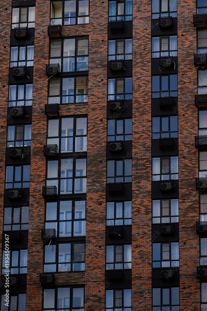 Obraz premium Apartment building facade with air conditioning units and brick exterior