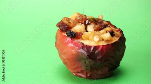 Mettere il miele sulla mela cotta al forno, ripiena di frutta secca, spazio per testo