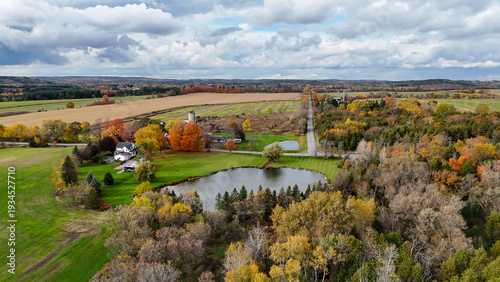 Foto Serene aerial view of a picturesque rural landscape with a farmhouse, pond, and
