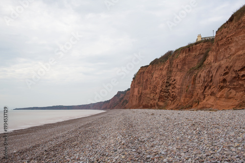 Budleigh Salterton beach in East Devon. A stony beach at the foot of high sandstone cliffs. The jurassic coast. Long exposure picture giving the sea a smooth look. 