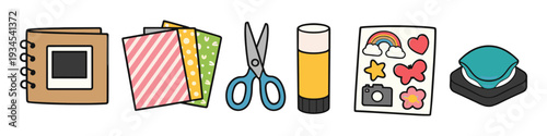 Cute scrapbook supplies including a photo album, patterned paper, scissors, glue stick, stickers, and a stamp