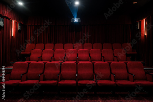 Empty cinema hall with red seats and projector light