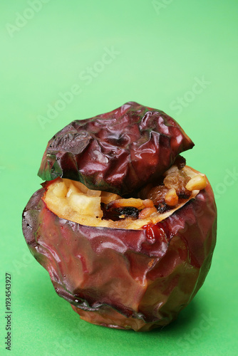 Primo piano di mela cotta al forno ripiena con frutta secca, spazio per testo