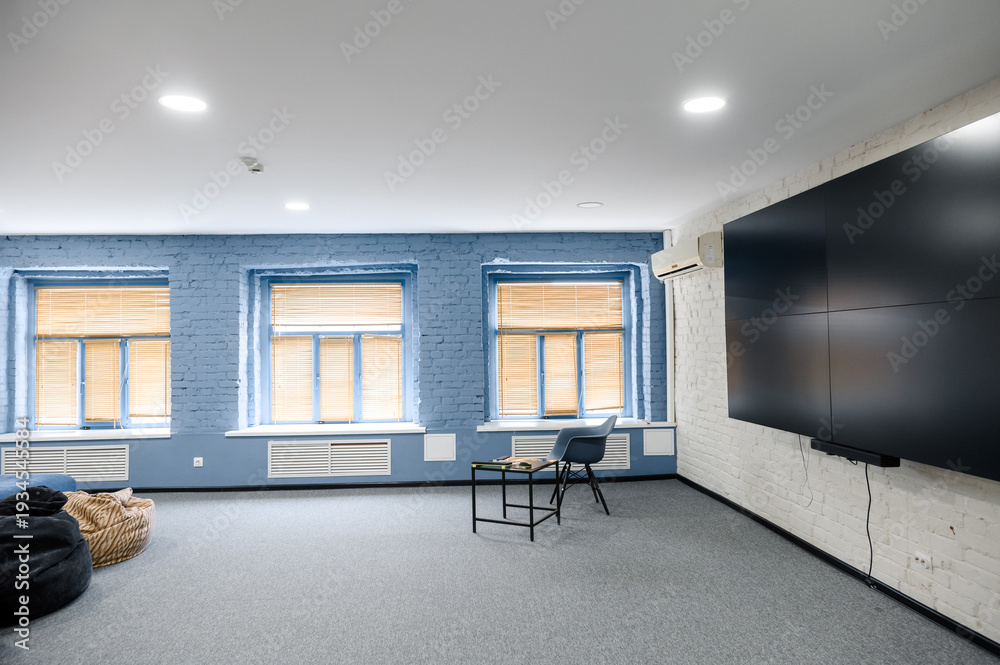 Fototapeta premium Modern office interior with blue walls and large screen
