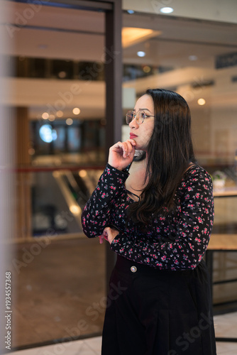 Thoughtful Woman Standing Indoors in Modern Public Space