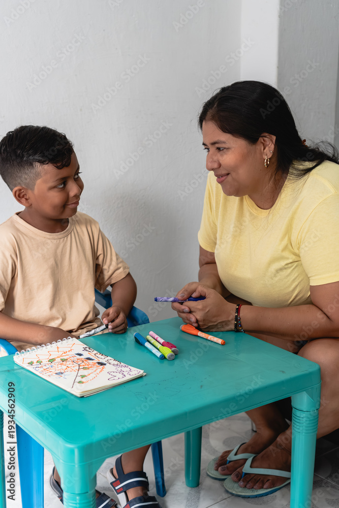 Fototapeta premium Mother and son coloring together during early childhood education