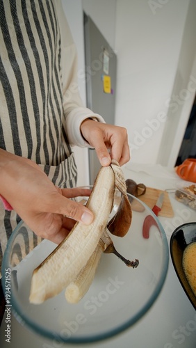 Cutting ripe banana on clean counter with prep bowl nearby for smoothies