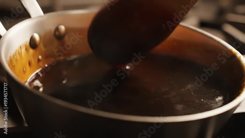 Simmering sauce in stainless steel pan for culinary and recipe content