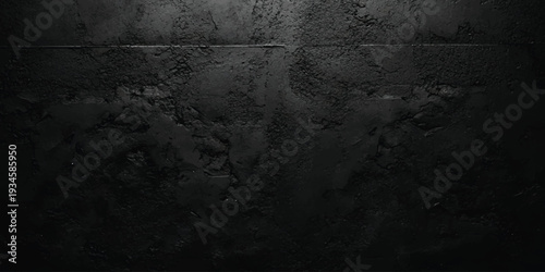 A dark and moody black concrete wall texture with a rough surface and dramatic lighting, creating an eerie background.