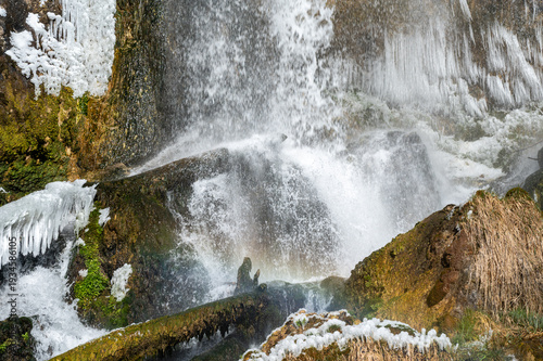Rifle Falls amidst snow and ice formations in Rifle Falls State Park, Colorado on exceptionally cold clear sunny winter morning.