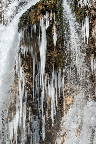 Large icicles and other ice formations adorn waterfalls at Rifle Falls State Park in Western Colorado on clear cold winter morning..