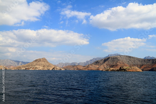Rocky Coastline of Musandam Rise Dramatically From Calm Deep Blue Water, Oman