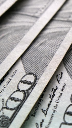 Vertical macro shot of one hundred US dollar bills. Close up of Benjamin Franklin portrait and treasury signatures on cash money. Financial success, wealth, and banking concept