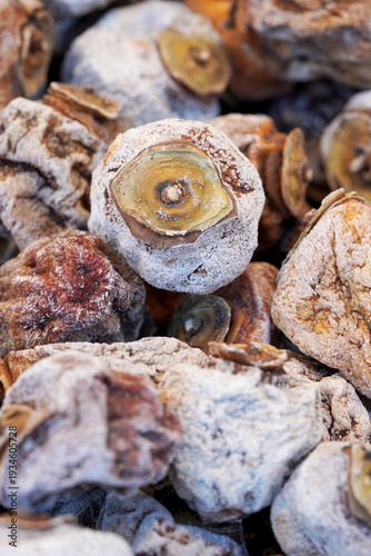 Top view close-up of traditional dried persimmons covered in natural white sugar powder, showing unique wrinkled texture and organic fruit preservation