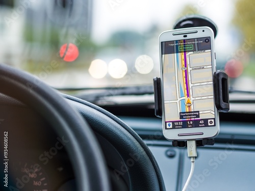 Smartphone with GPS navigation app providing directions inside a moving car.
