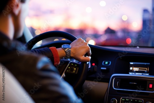 Man wearing a stainless steel watch driving a car during twilight city commute