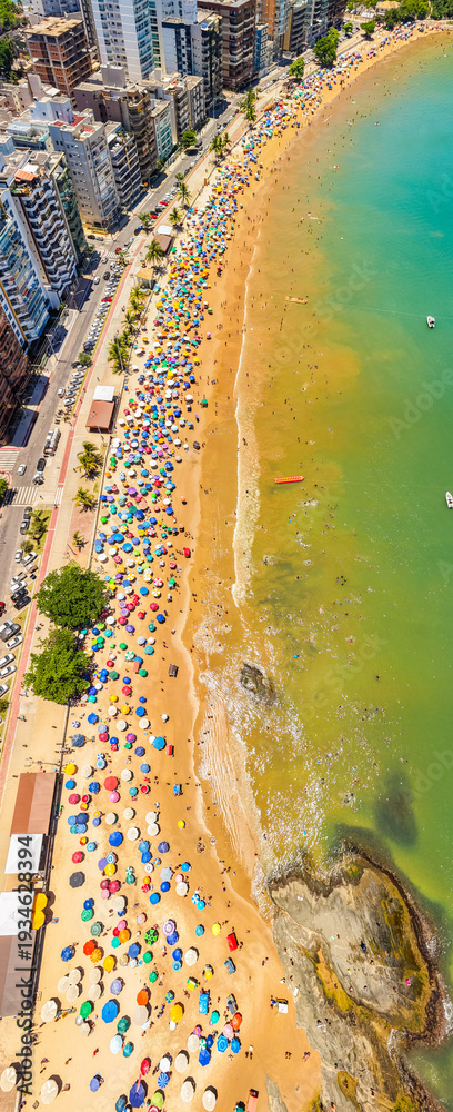 Obraz premium Aerial view of crowded Praia do Morro beach during summer tourism season in Guarapari Brazil