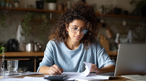Busy young woman homeowner using calculator laptop to view utility documents track bill receipts