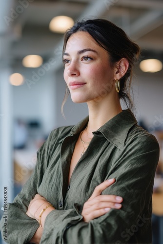 Confident Woman: A portrait of a composed woman exuding a sense of confidence, her gaze filled with determination and optimism, set against a backdrop suggesting an office environment.