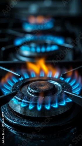 Close-up of blue and orange flames on a black gas stove