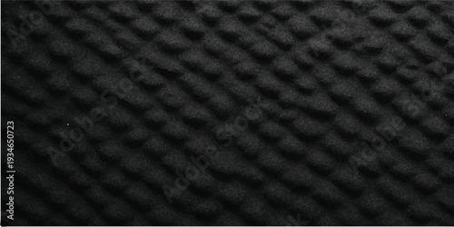 Detailed black rubber mat texture featuring patterns similar to vehicle tire designs, suitable for use in industrial, automotive, or abstract design projects
