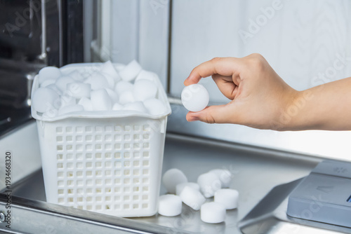 Canvas-taulu Woman hold a salt pellet in your hand to soften the water for the care of the appliance