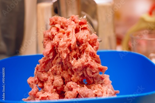 Wallpaper Mural Fresh bright red meat freshly ground into mince, placed next to a meat grinder in a blue bowl. Homemade meat preparation. Torontodigital.ca