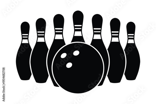A black bowling ball sits in front of several bowling pins in monochrome