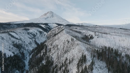 Aerial drone footage over a snow-covered volcanic mountain landscape with river valleys.