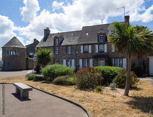 Típicas construcciones de casas con buhardillas, tejados oscuros y plantas verdes en la calle en el pueblo Barfleur, en la Normandía francesa, viajando verano 2022