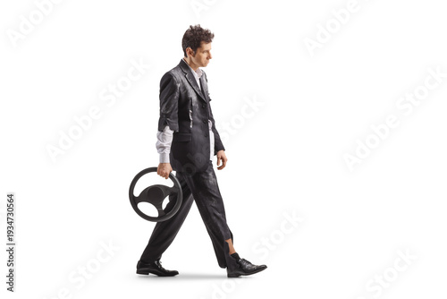 Schilderij op canvas Pensive man in a torn suit walking and holding a steering wheel