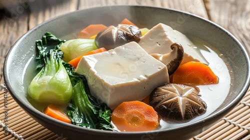 Vegetable and tofu soup in bowl on bamboo mat