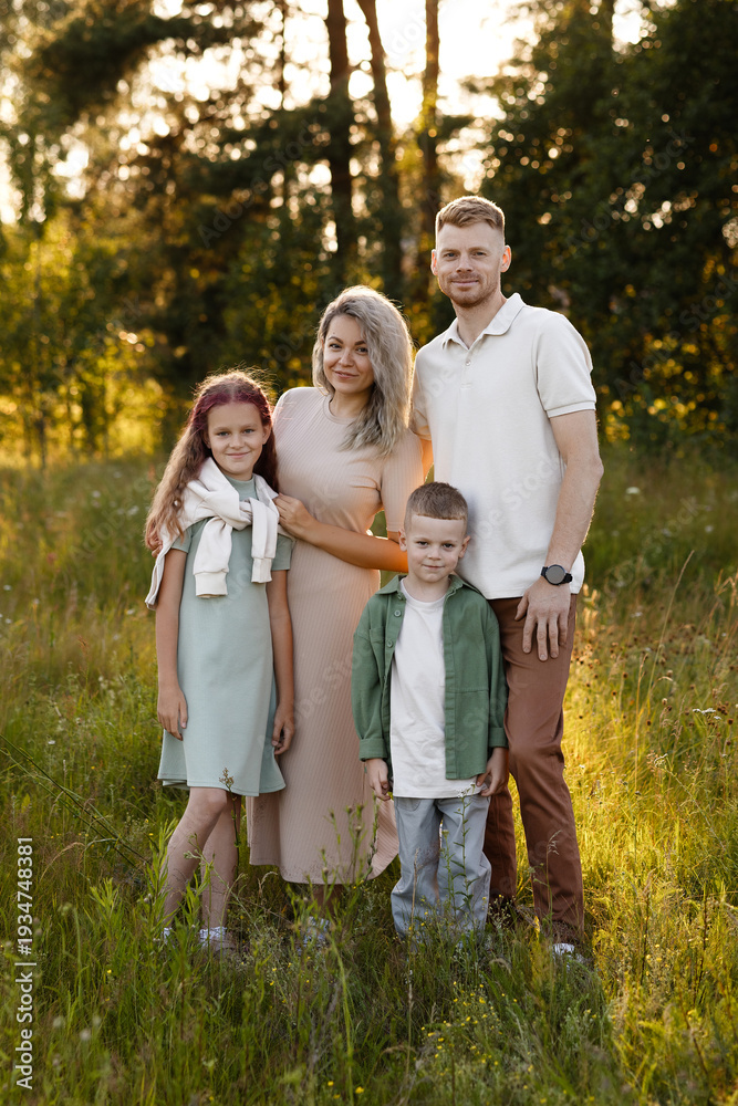 Fototapeta premium Family In Sunlight. Joyful Family In Natural Setting. Caucasian Family Posing In Sunlit Meadow. Family Enjoying Peaceful Moment Together In Sundrenched Meadow During Sunny Day