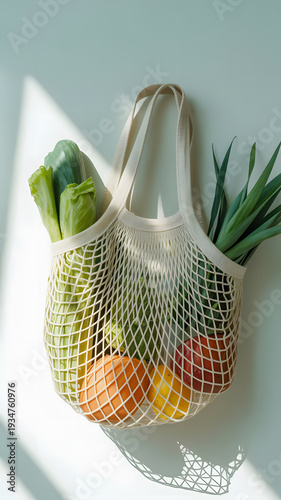 Mesh bag with fresh produce on white background